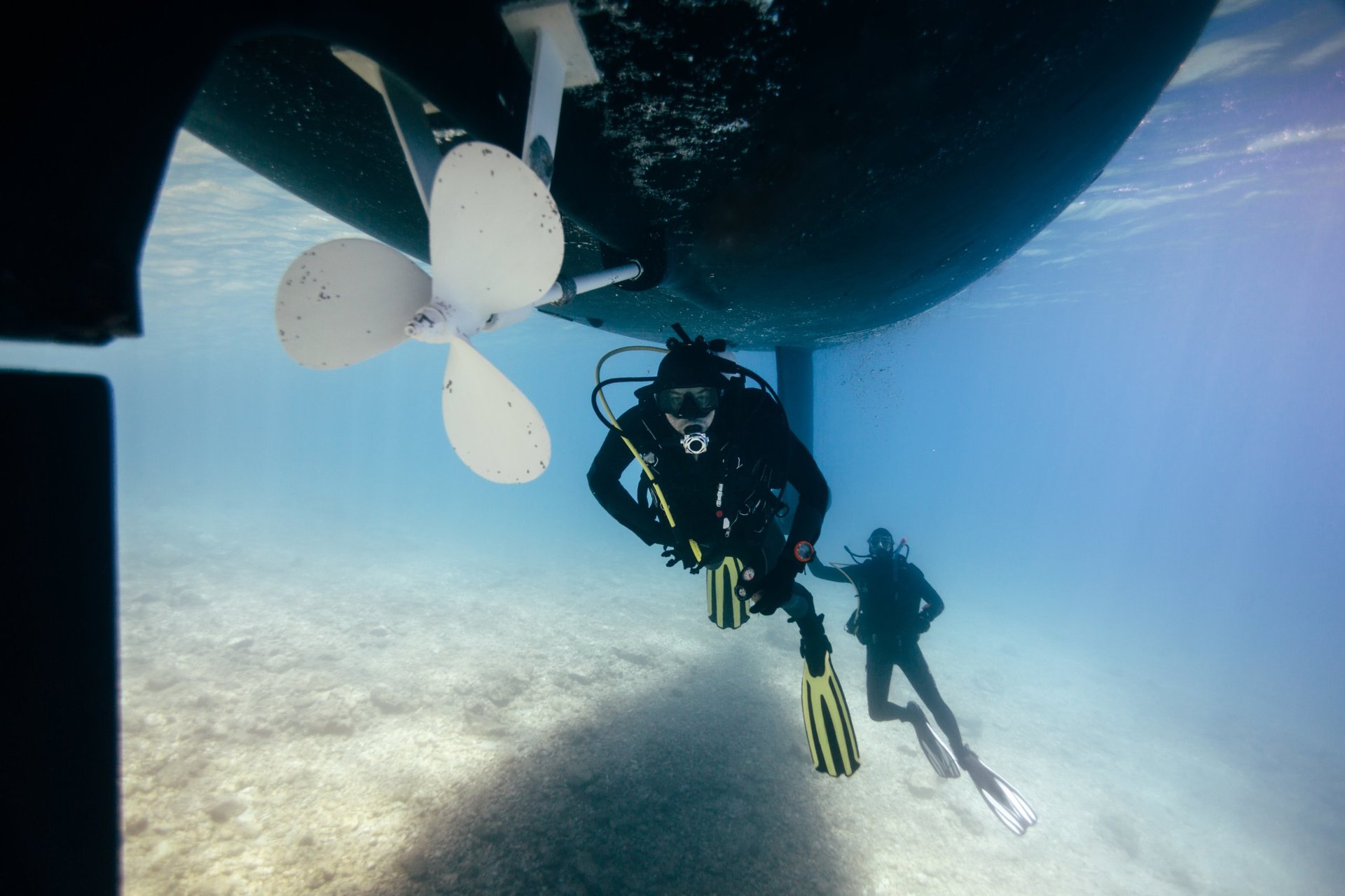 Two technical divers repairing a ship propeller underwater